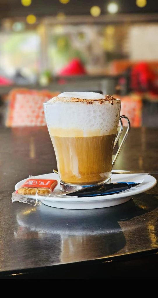 Cappuccino sur soucoupe, biscuit et cuillère au Restaurant Le Progrès, Bormes-les-Mimosas, depuis 1909.