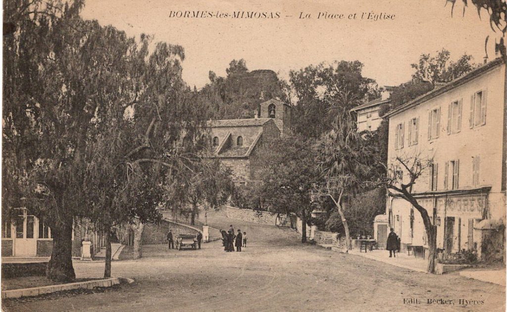 Place du village, église et arbres face au Restaurant Le Progrès, institution depuis 1909.