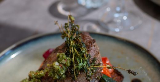 Assiette raffinée : steak grillé, légumes et sauce verte, tradition à Bormes-les-Mimosas depuis 1909.