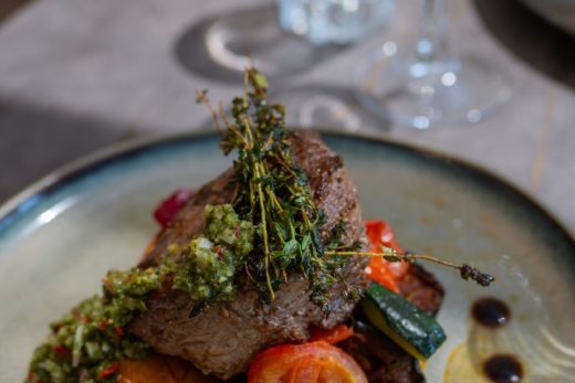 Assiette raffinée : steak grillé, légumes et sauce verte, tradition à Bormes-les-Mimosas depuis 1909.
